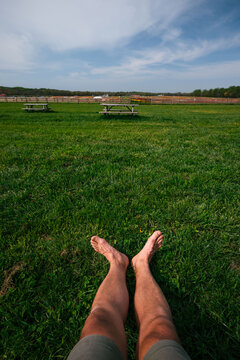 Relaxing on the Grass With Feet Stretched out in a Field