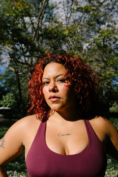 A plus-size woman facing the camera wearing a serious expression