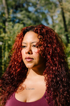 A close natural light portrait shows a curvy woman