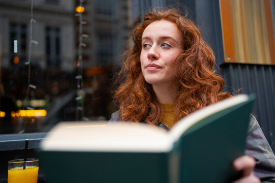 Woman reading book at cafe table