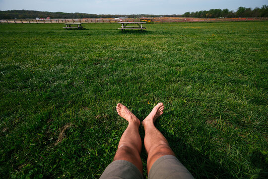 Relaxed view of legs on grass facing a field