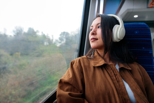 Smiling woman with headphones on train