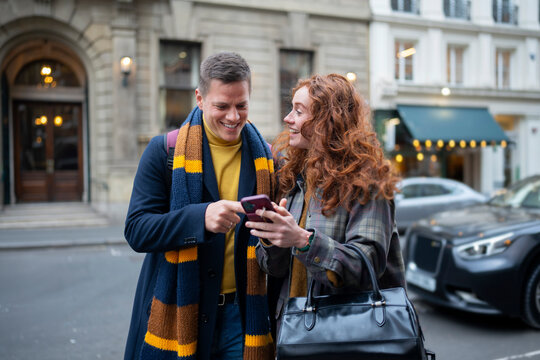 Smiling while sharing smartphone content in London
