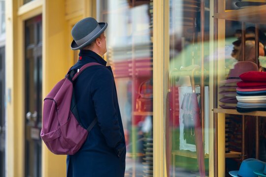 Man looking at shop window in city