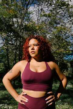 Portrait of empowered woman posing in athletic wear in a public park