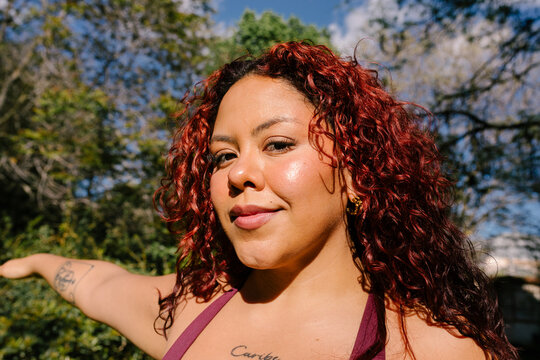 A close-up portrait of a woman who is proud of her body