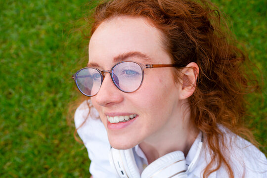 Smiling woman relaxing on grass in park