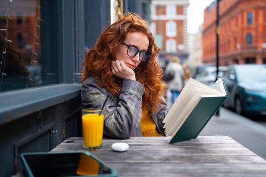 Woman reading at cafe with juice