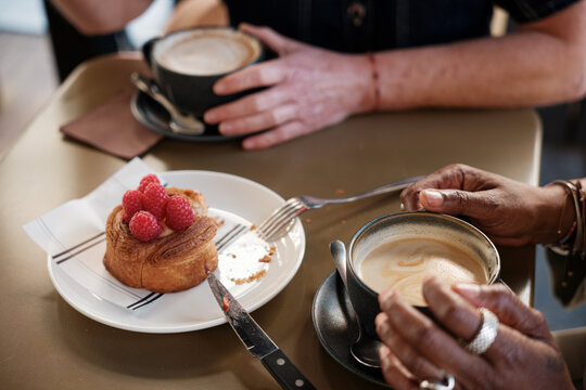 Anonymous friends having pastry and coffee