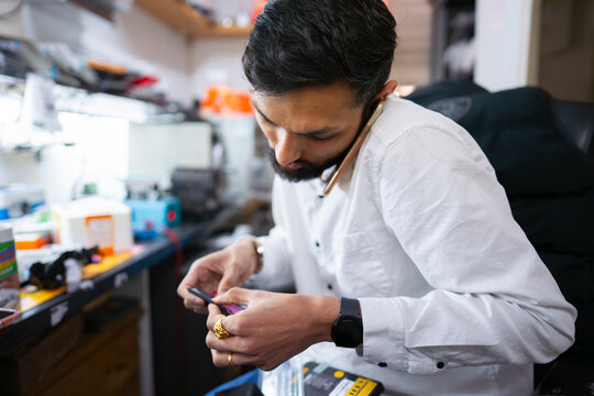 Technician repairing smartphone hardware