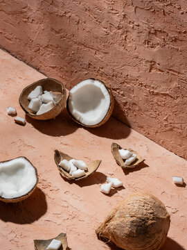 Fresh Coconut Halves with Pieces Scattered on a Textured background