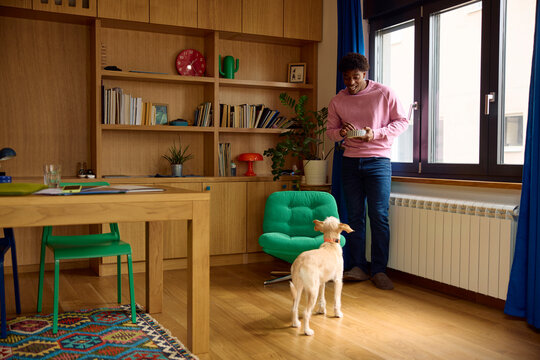 Man holds a bowl of food for his dog
