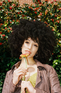 Woman with big afro holding a flower