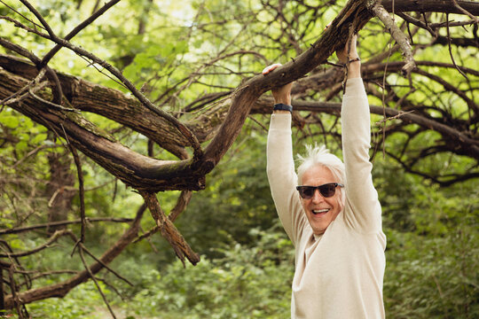 Senior Man Swings from a Branch