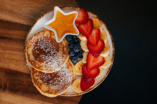Healthy pancake breakfast bowl with fruit and maple syrup