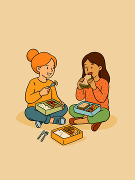 Girls eating lunch at picnic enjoying bento box food