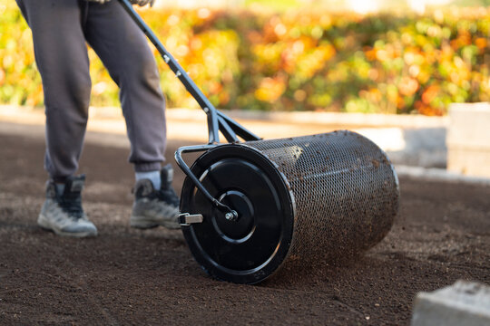 Man Walking While Leveling Soil