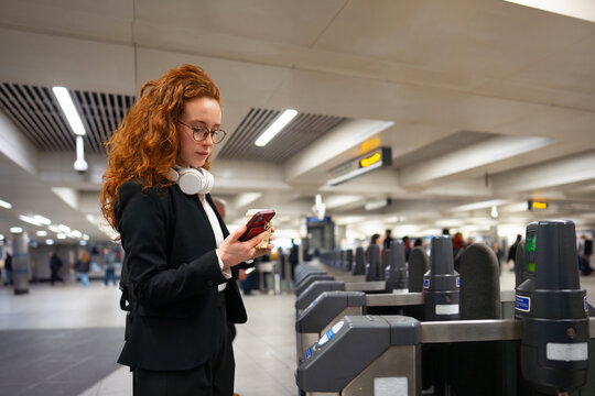 Woman entering subway station using phone
