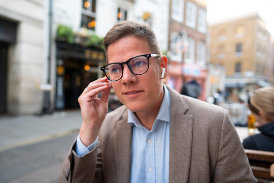 Close up of man with wireless earbuds in city
