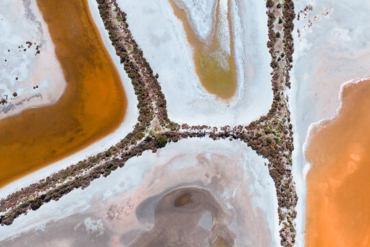 Colourful water with patterns and shapes in a drying salt lake