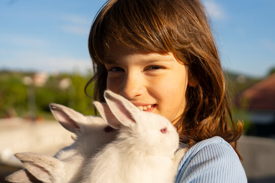 Girl holding white rabbits