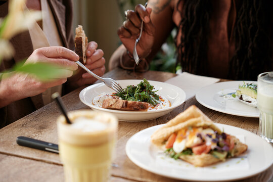 Anonymous friends having brunch on a restaurant