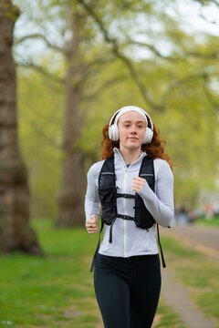 Woman jogging toward camera in park
