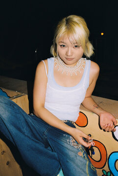 Subtle smile portrait against faded orange wall at night
