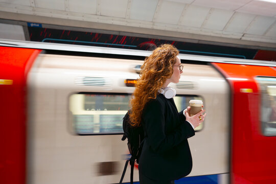 Commuter walking past moving subway train