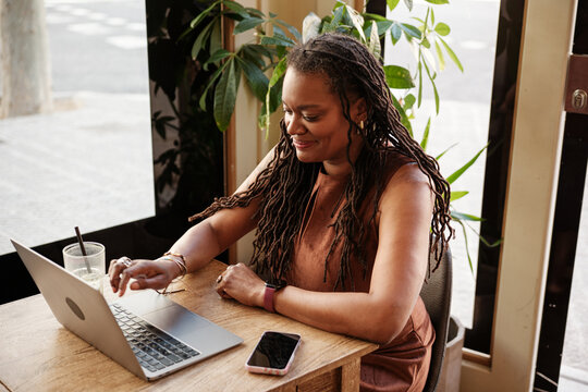 Business woman using laptop at a cafe