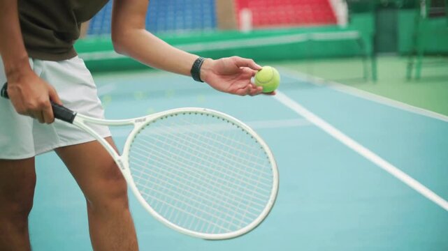 Man holding tennis racket on blue court with colorful seats