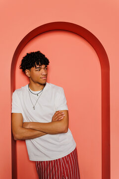 Man leaning on arch confidentially posing on colored background