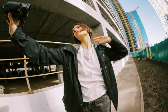 Person Holds Camera While Standing at Construction Site in Daylight