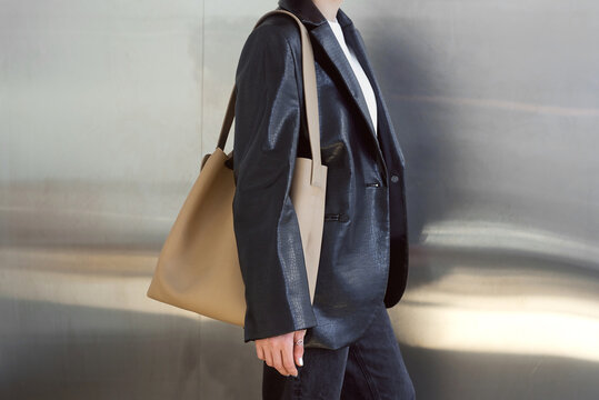 Woman carrying beige leather bag