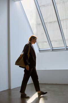 Woman walks inside a modern building with large windows