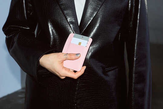 Woman holding a pink wallet with credit cards