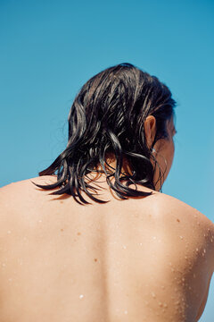 Woman with wet hair under a clear blue sky