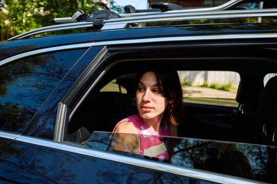 Portrait of a young woman sitting in the back of a car