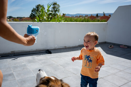 Happy toddler child laughing playing with bubbles outdoor
