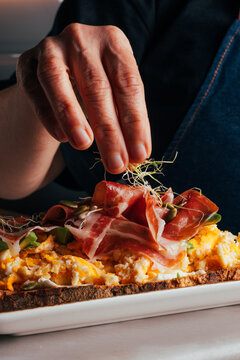 Gourmet toast with prosciutto, eggs, shoots and seeds