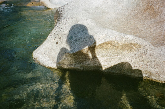 Silhouette of a woman against river rock and water