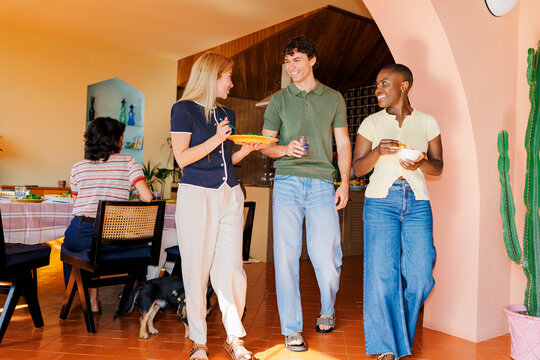 Group of friends enjoying home meal walking and talking together