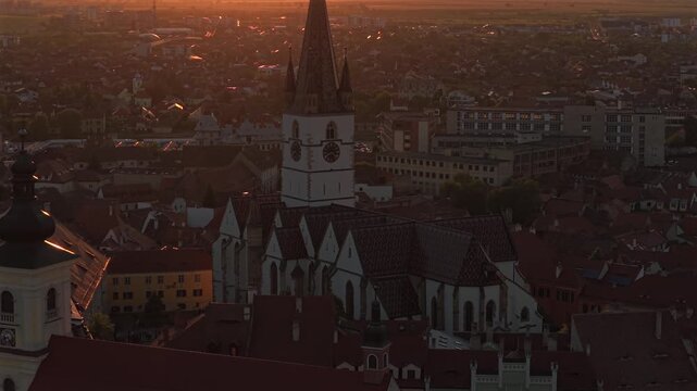 Aerial sunset 4k video of the Great Square in Sibiu, showing historic buildings, the Catholic and Lutheran Church, and the council tower, sunset landscape. Sibiu Transylvania landmarks. Romania video