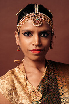 Indian woman wearing traditional golden jewelry and saree