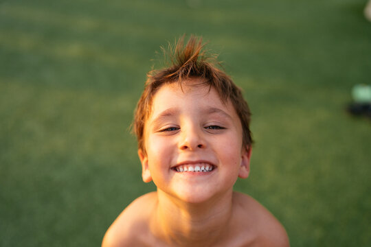 Happy smiling boy playing outdoors on grass