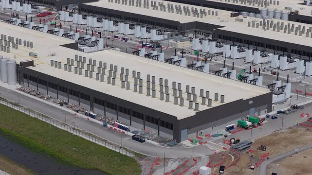 Aerial construction view of a large scale AI data center facility with electrical systems, cooling infrastructure, and server hall preparation