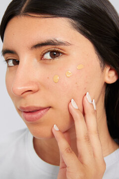 Woman applying foundation drops for natural beauty routine