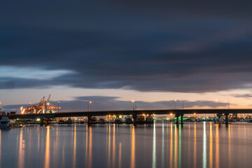 Naklejka premium Tauranga Harbour Bridge lights and reflections before sunrise