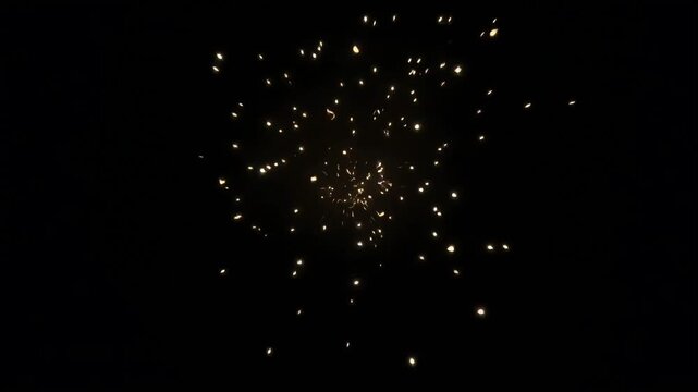 Fire ring explosion video effect with glowing golden particles scattering outward into darkness in a high quality digital animation