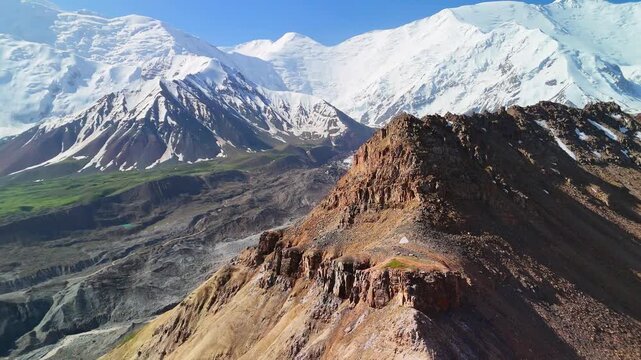 Aerial view of Base Camp for Peak Lenin with snow-capped mountains and rocky ridges in Chong-Alay District, Osh Region, Kyrgyzstan.